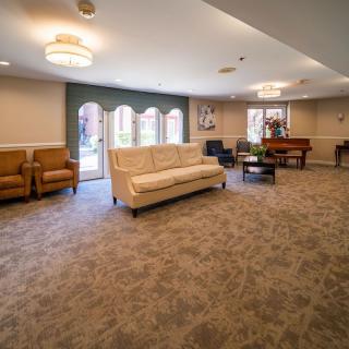 A spacious and comfortable living room with seating arrangements, large windows, and elegant lighting.