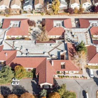 Aerial view of a residential area with buildings and autumn-colored trees.