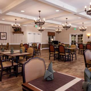 An elegant dining room with neatly arranged tables and chandeliers.