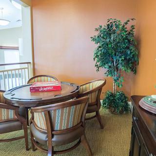 A cozy indoor dining area with a round table, chairs, and a potted plant.