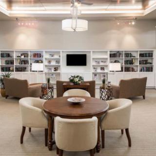 A stylish library with a central seating area and surrounding bookshelves.
