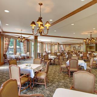 A spacious dining area with elegant furnishings and chandeliers.