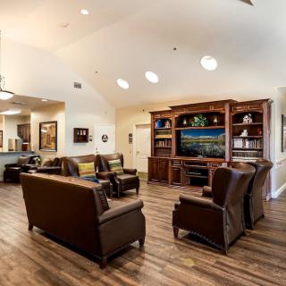 Spacious living room with comfortable seating and wooden shelves.