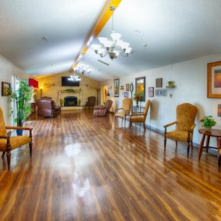 A spacious living room with wooden flooring, comfortable seating, and elegant decor.