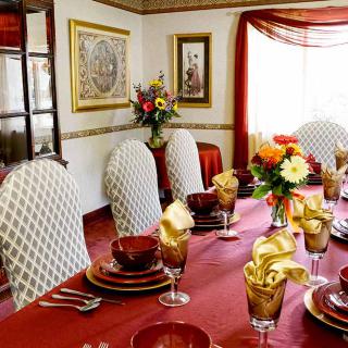An elegantly set dining table with decorative elements and a floral centerpiece.