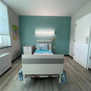 A modern, clean hospital room equipped with a patient bed and minimalist decor.