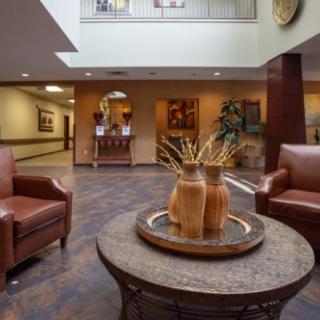 A well-decorated lobby with armchairs and a table centerpiece.