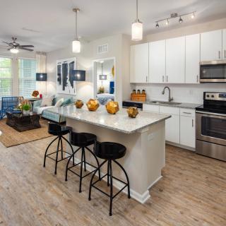 A modern open-concept kitchen with a central island, stylish pendant lights, and sleek appliances.