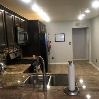 A modern kitchen with dark wood cabinets, stainless steel appliances, and granite countertops.