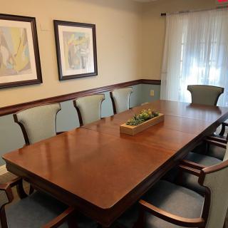A well-appointed dining room featuring a large wooden table surrounded by chairs and adorned with wall art.