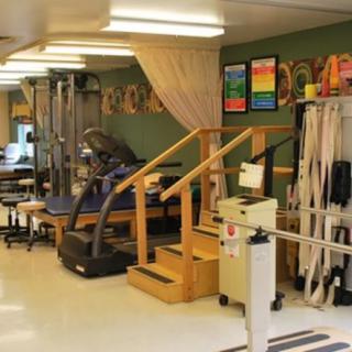A physical therapy room equipped with rehabilitation and exercise equipment.