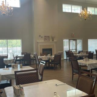 Spacious dining area with elegant chandeliers and a cozy fireplace.
