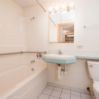 A simple and functional bathroom featuring a bathtub, sink, and toilet.