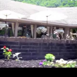A beautifully landscaped garden with various flowers in front of a building.