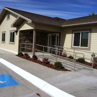 A modern building featuring handicap accessibility with a ramp and landscaped surroundings.