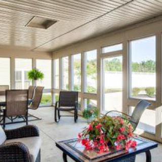 A bright and cozy sunroom with comfortable seating and abundant natural light.