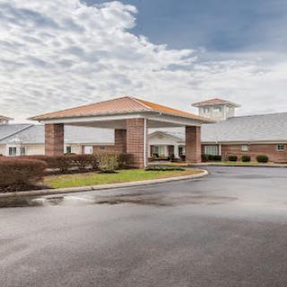 A welcoming hotel entrance under a cloudy sky.