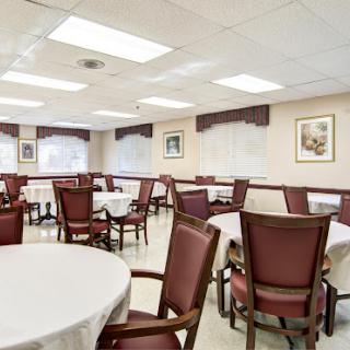 A spacious and well-lit dining room with neatly arranged tables and chairs, ready for patrons.