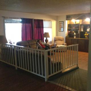 A cozy living room with a sectional sofa and a pet gate for added comfort.