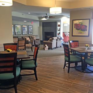 A cozy dining area with tables and chairs, soft lighting, and colorful decor.