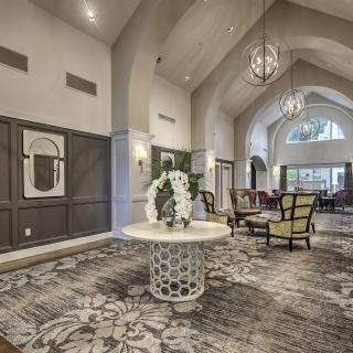 A spacious and elegantly designed lobby with high ceilings, modern decor, and comfortable seating.