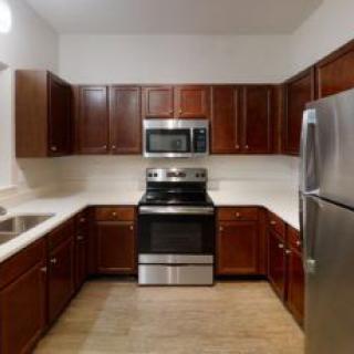 A modern kitchen with stainless steel appliances and wood cabinets.
