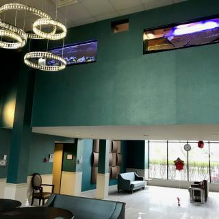 A modern lobby area featuring elegant chandeliers, comfortable seating, and large windows.