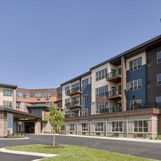 Modern residential apartment building with balconies and landscaped surroundings.