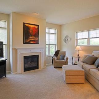 A cozy living room featuring a comfortable sofa, an armchair, and a modern fireplace.