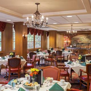 An elegant dining room with neatly arranged tables and chandeliers.