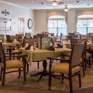 A cozy dining area with neatly arranged tables and chairs, featuring elegant decor and natural lighting.