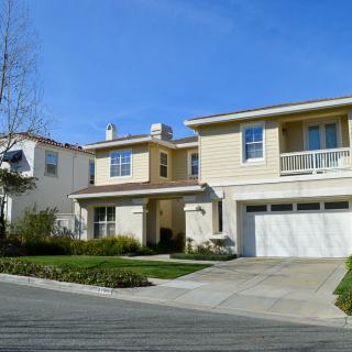 A two-story suburban house with a large driveway and garage.
