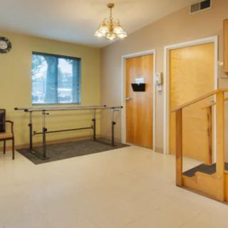 A room designed for physical therapy featuring parallel bars and a staircase.