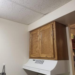 View of a kitchen with wooden cabinets and a range hood.