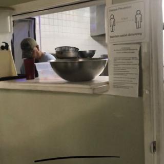 A kitchen scene with stacked metal bowls and a person in the background.