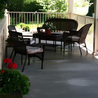 A cozy patio with wicker furniture and potted plants, perfect for relaxation.
