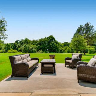 A cozy outdoor patio setup with comfortable seating overlooking a lush, green landscape.