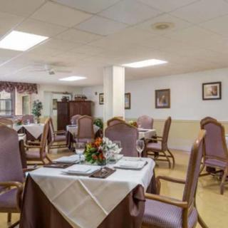 A cozy dining area with elegantly set tables and comfortable chairs.