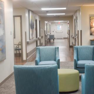 A modern waiting area in a hospital, featuring comfortable blue chairs and an inviting atmosphere.