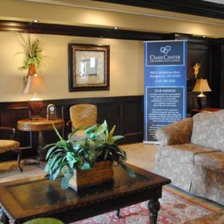 A cozy lobby area with a sofa, table, and decorative plants, featuring a promotional banner.