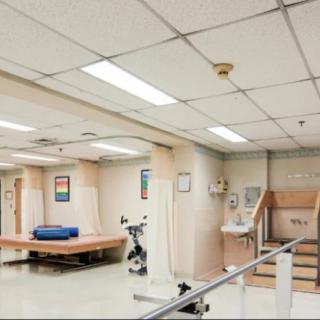 A rehabilitation room in a hospital equipped with exercise equipment and therapy tools.