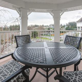 A cozy outdoor seating area in a gazebo overlooking a scenic landscape.