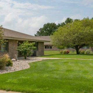 A suburban house with a well-maintained lawn and trees.