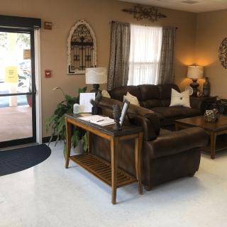 A cozy waiting area with sofas, lamps, and decor creating a welcoming atmosphere.