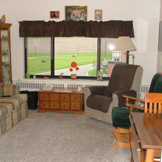 A cozy living room with a sofa, chairs, and a large window overlooking the outdoors.