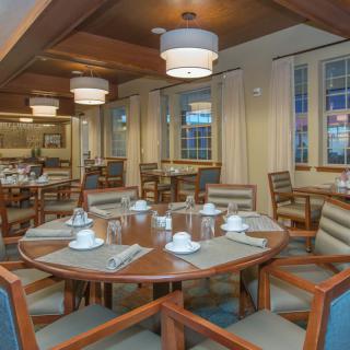 A cozy dining room setup with neatly arranged tables and chairs, ready for guests.