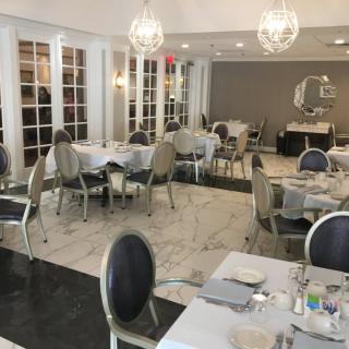 An elegantly decorated restaurant dining room with tables and chandeliers.