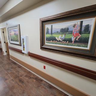 A well-lit hallway featuring framed paintings, enhancing the interior decor.