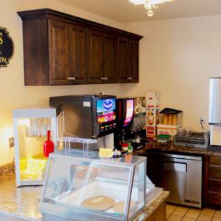 A small concession stand featuring a popcorn machine, soda fountain, and various kitchen appliances.