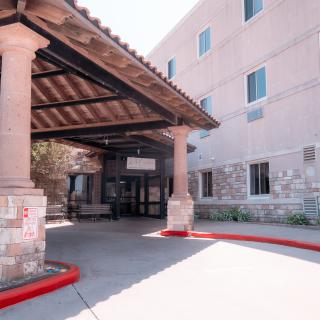 The exterior of a building with a covered entrance supported by columns.